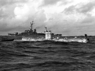 Der Bathyscaph Trieste liegt an der Wasseroberfläche über dem Marianengraben, im Hintergrund fährt der Geleitzerstörer USS Lewis
