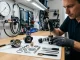 Techniker wartet einen zerlegten Atemregler mit O-Ringen und Werkzeugen.