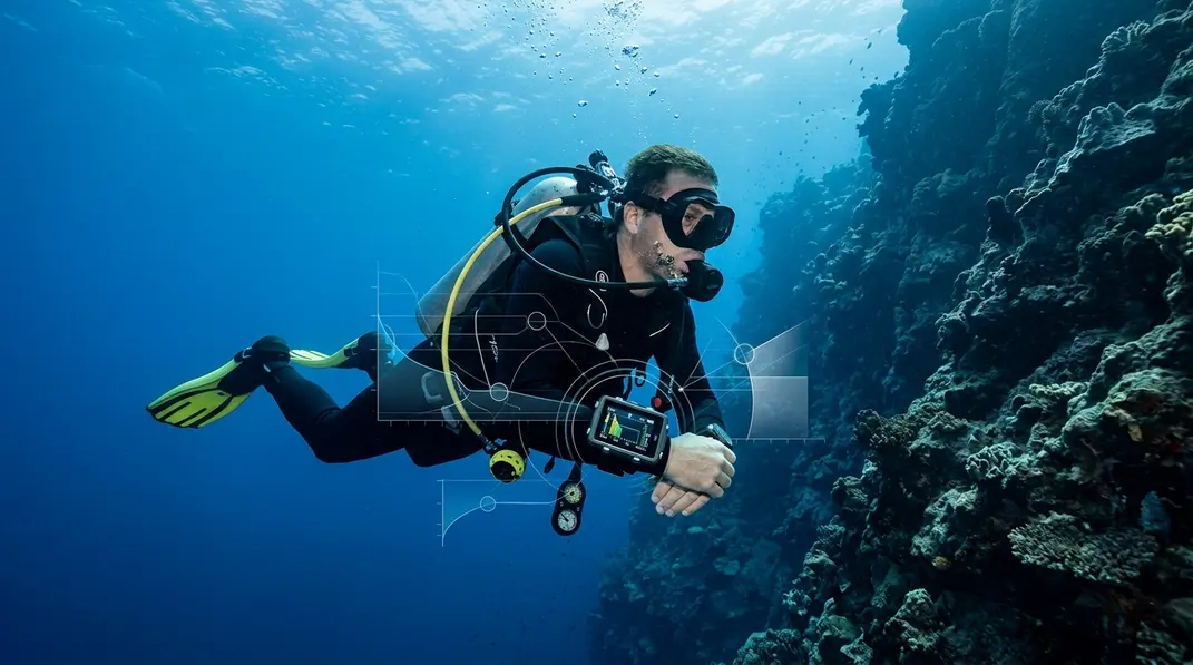 Taucher mit Tauchcomputer vor einer blauen Steilwand und grafischen Symbolen f&uuml;r Druckgrenzen.