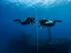 Zwei Taucher im Deep Diver Specialty steigen kontrolliert an einer Leine zu einem tief liegenden Wrack ab.