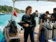 Divemasterin auf einem Tauchboot betreut Gäste und bereitet einen Tauchgang vor.