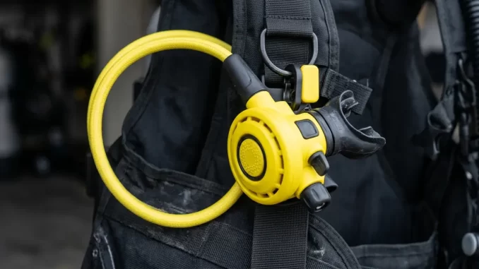 Gelber Ersatzatemregler mit gelbem Mitteldruckschlauch, an der rechten Brustseite eines Tarierjackets befestigt.