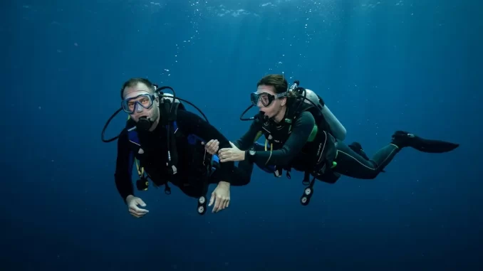 Ein Taucher hält seinen Partner im Freiwasser mit beiden Händen fest und stabilisiert ihn