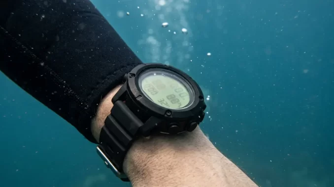 Tauchcomputer am Handgelenk eines Tauchers, Nahaufnahme unter Wasser.