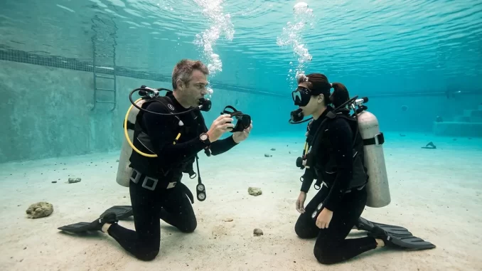 Ein Tauchlehrer kniet im flachen Wasser vor einem Tauchschüler und zeigt ihm eine Übung.