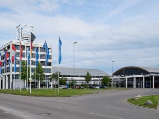 Gelände der Messe Friedrichshafen mit Fahnenmasten, Verwaltungsgebäude und Hallen