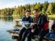Zwei Tauchanfänger bereiten sich am See gemeinsam auf die Open Water Diver Theorieprüfung vor.