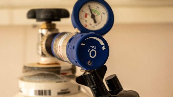 Sauerstoffflasche mit blauem Druckminderer, Manometer und einem Flowregler mit Literanzeige