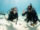 Beim Schnuppertauchen Ablauf begleitet ein Tauchlehrer eine Anfängerin in flachem Wasser.