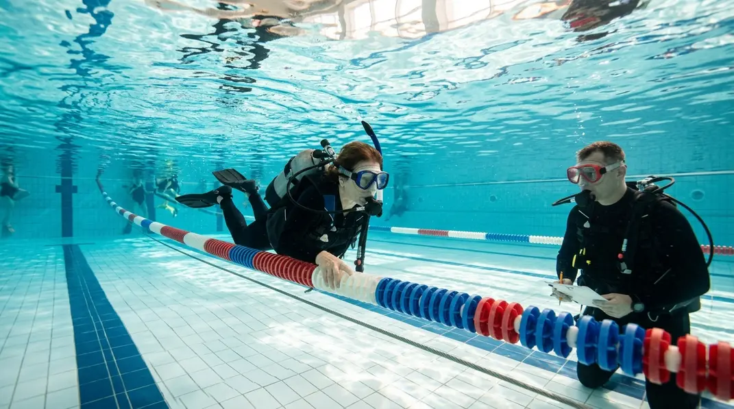 Tauchanf&auml;nger absolviert einen Schwimmtest mit Maske und Flossen im Schwimmbad.