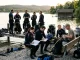 Eine Tauchgruppe bereitet am Seeufer Ausrüstung vor und tauscht sich nach einem Tauchgang aus.