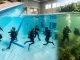 Tauchanfänger trainieren während der Tauchausbildung im Freiwasser und im geschützten Becken mit einem Tauchlehrer.