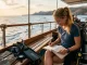Taucherin schreibt Tauchlogbuch Einträge auf einem Boot nach einem Tauchgang.