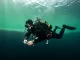 Taucher an einer deutlich sichtbaren Sprungschicht zwischen hellem Oberflächenwasser und dunklem Tiefenwasser.