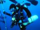 Technischer Taucher mit Doppelgerät, Stageflasche und Tauchcomputer hält sich beim Dekompressionsstopp an einer Leine im freien Wasser
